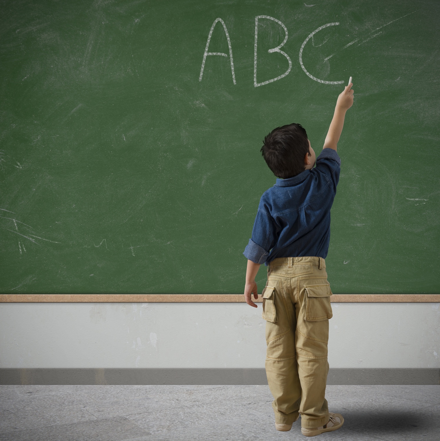 kid writing on chalkboard